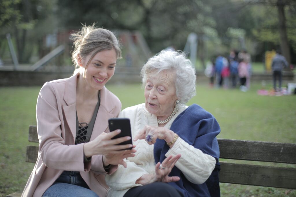 Direct Support Professional assisting elderly woman with her Cellular Device